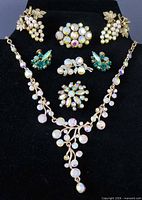 Full lot on black bust displaying necklace, brooches, earrings