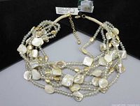 Full view of multi-strand necklace with tag attached showing clasp and extender