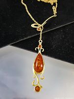 Full view of lariat necklace showing chain and amber drop