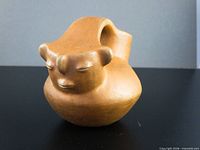 front view of signed Diaguita style figural clay vessel showing head motif