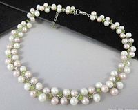 Full view of pearl and peridot cluster choker necklace laid flat showing overall design and extender chain