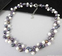 Full view of necklace laid flat showing pearl and amethyst clusters and extender chain