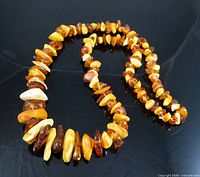 Full view of the entire necklace coiled on black background