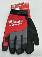 Front view of Milwaukee lightweight duty work gloves on retail card showing logo, size 9/L and features