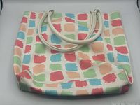 Full view of tote exterior showing multicolor pattern and handles