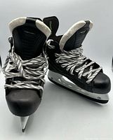Front view of both skates showing tongues, laces and blade tips