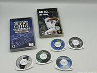 Front view of two PSP game cases and six UMD discs