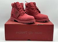 Front angled view of both red Timberland youth boots on original box