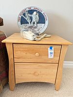 Front view of bedside table with plaque and phone on top