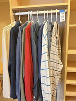 Closet rod view of all 10 tops hung on white hangers