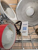 Two aluminum clamp reflector lamps with bulbs and cords visible