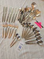 Overview of entire assorted flatware set with knives, forks, spoons, ladle