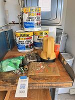 Overall lot view with paint cans, flashlight, hardware on bench
