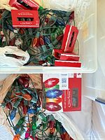 Overview of storage bin containing tangled C9 light strings, replacement bulb boxes, packaging