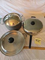 Three cookware pieces with lids displayed