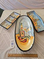 All three ceramic serving pieces laid out with ruler for scale