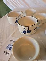 White mugs with blue duck motif and ramekins visible
