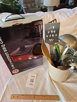 Boxed appliance next to utensil crock showing all contents and scale