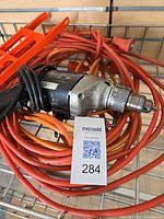 Drill coiled with extension cords and adapters visible