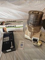All three items: assembled Cuisinart food processor, Cuisinart electric knife box, Ovente hand blender box, lot card visible