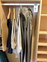 Five pairs of trousers hanging on rail showing colour range and overall condition