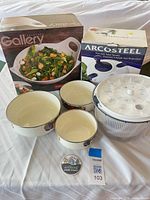 Overall lot showing boxed stoneware bowl, boxed salad spinner, three enamel bowls