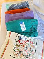 Stacked view of four beach towels and North Carolina kitchen towel