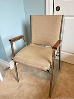 Single chair showing overall design, chrome frame, beige upholstery, wood armrest caps