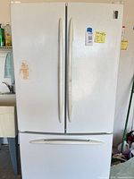 Front view of white GE Profile French door refrigerator with bottom freezer drawer