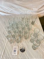 Group of 26 clear glasses on table
