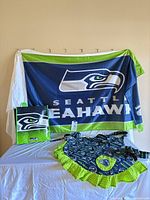 All three team-branded items displayed together: banner, tote bag, apron