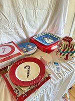 Group view showing candy-cane plates, boxed sets, blue cartoon plates, snowman platter box and gift cookie jar
