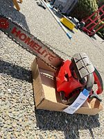 Full view of chainsaw resting in cardboard tray