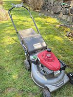 Full view of Honda self-propelled lawn mower showing deck, engine, handle and overall wear