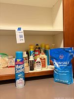 Front view showing Magic Sizing can, Kroger Epsom Salt bag and assorted cleaners inside cabinet