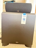 Front view of Klipsch KSW-12 subwoofer with center speaker resting on top