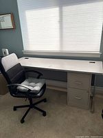 Desk with chair positioned in front, showing overall size, desktop, cable grommets, metal legs, file pedestal