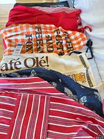 Stack of five assorted aprons showing variety of colours and prints