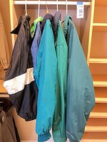 Four jackets hanging on rail showing colors and styles