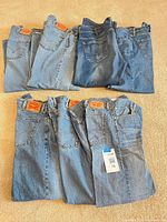 Seven pairs of Levi's jeans laid flat in two rows