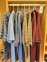 Front view of the eight collared shirts hanging on rail