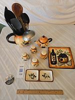 full lot showing pitcher with utensils, teapot, shakers, condiment dish, plate and ruler for scale
