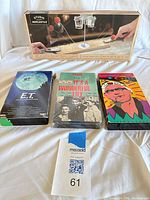 Entire lot: boxed wooden basketball game and three VHS tapes side by side