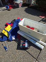 Group shot of cooler, life jackets, buoys, charts, radio box, rope