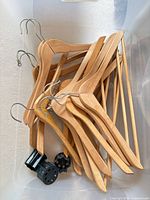 Bin showing several wooden suit hangers
