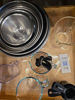 All items overview: nested metal bowls, three glass measuring cups, plastic cup, spoon set