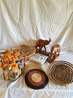 full lot overview showing carvings, floral arrangement, woven pieces, marble slab