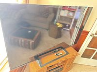 Front view of Sony 60-inch TV on stand with remote visible