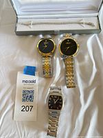 Group shot of three watches and bracelet in case