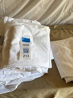 Folded white sheet set and other linens